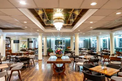 a restaurant with wooden tables and chairs and tablesktop at Forest Park Hotel in Platres