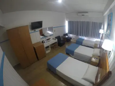 a hotel room with two beds and a television at Asty Hotel in Nicosia