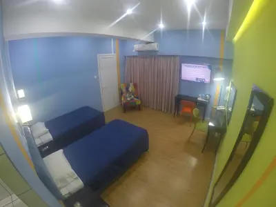 a small room with a blue bed and a table at Asty Hotel in Nicosia