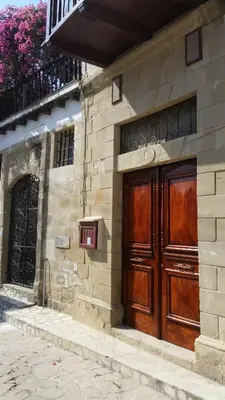 a building with two wooden doors on the side of it at Kalavasos Square Apartments - With Access to Shared Pool 3 Minutes Walk in Kalavasos