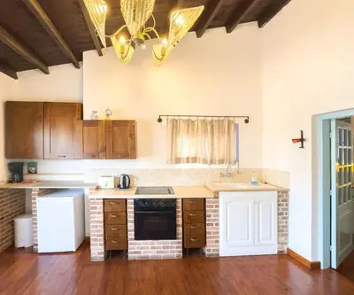 a kitchen with wooden cabinets and a stove top oven at Kalavasos Square Apartments - With Access to Shared Pool 3 Minutes Walk in Kalavasos