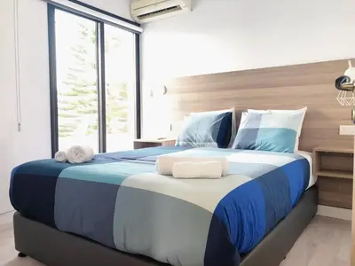 a bedroom with a large bed with blue and white sheets at Metro Court Apartments in Limassol