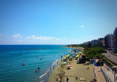 a beach with a bunch of people in the water at Metro Court Apartments in Limassol