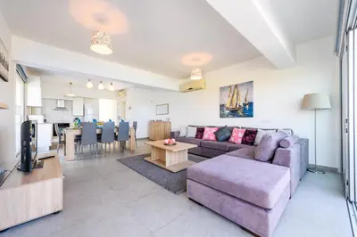 a living room with a couch and a table at Ayia Triada View in Protaras