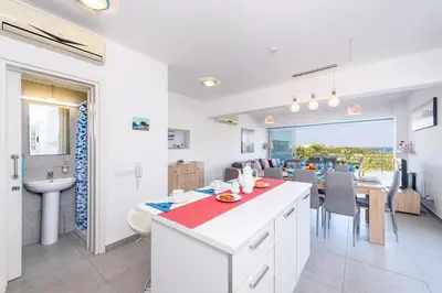 a kitchen and dining room with a table and a sink at Ayia Triada View in Protaras