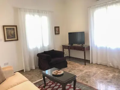 a living room with a couch and a tv and a table at Avgi's Home in Limassol