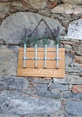 a wooden box with three plants in it on a stone wall at To Apokentro in Alona