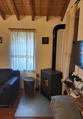 a living room with a wood stove in a room at To Apokentro in Alona
