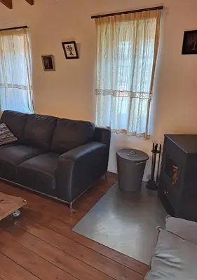 a living room with a leather couch and a fireplace at To Apokentro in Alona