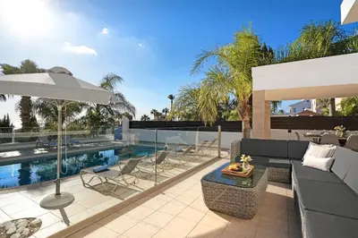 an outdoor patio with a couch and an umbrella at Villa Harmony in Protaras