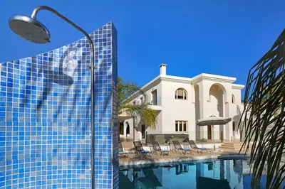 a building and a street light next to a swimming pool at Villa Harmony in Protaras
