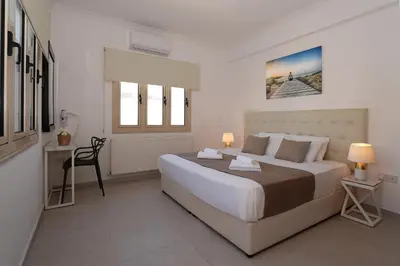 a bedroom with a large bed and a desk at Villa Harmony in Protaras