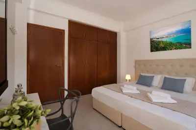 a bedroom with a bed and a table with a chair at Villa Harmony in Protaras