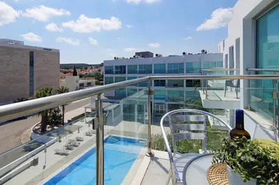 a balcony with a bottle of wine on top of a building at Apartment Erika in Protaras