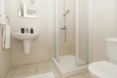 a bathroom with a shower and a toilet and a sink at Amber - Coralli Beachfront Apartment in Protaras