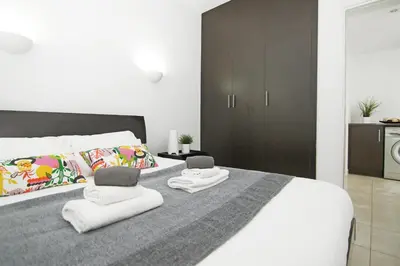 a bedroom with a large bed with two towels at Amber - Coralli Beachfront Apartment in Protaras