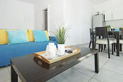 a living room with a blue couch and a table at Amber - Coralli Beachfront Apartment in Protaras