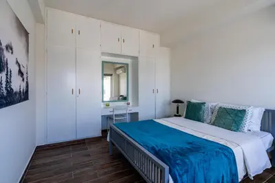 a bedroom with a bed and white cabinets at Engomi Apartment in Yukarı Lakatamya