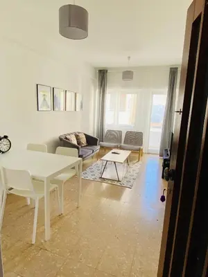 a living room with a white table and a couch at Engomi Apartment in Yukarı Lakatamya