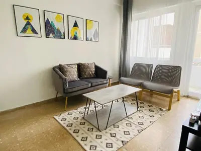 a living room with two chairs and a table at Engomi Apartment in Yukarı Lakatamya
