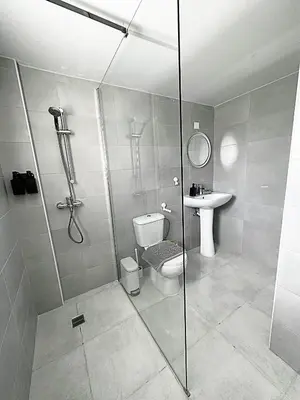 a bathroom with a shower and a toilet and a sink at Engomi Apartment in Yukarı Lakatamya