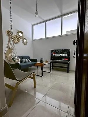 a living room with a hammock and a tv at Engomi Apartment in Yukarı Lakatamya