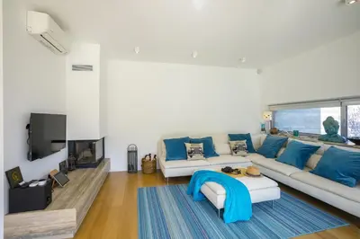 a living room with a white couch and blue pillows at Protaras Villa Zen in Protaras