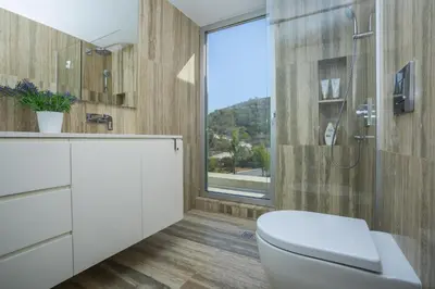 a bathroom with a toilet and a glass shower at Protaras Villa Zen in Protaras