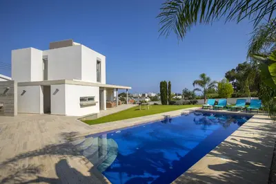 a villa with a swimming pool in front of a house at Protaras Villa Zen in Protaras