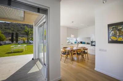 a kitchen and dining room with a table and a view of a yard at Protaras Villa Zen in Protaras