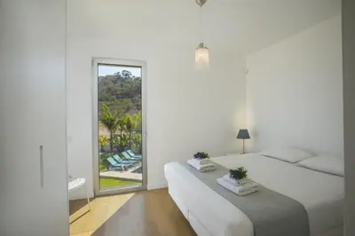a white bedroom with two beds and a mirror at Protaras Villa Zen in Protaras