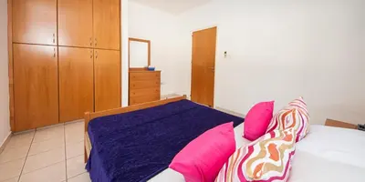 a bedroom with a bed with pink and purple pillows at Villa Stefanie in Ayia Napa