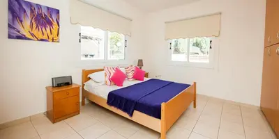 a bedroom with a bed with pink and blue sheets at Villa Stefanie in Ayia Napa
