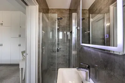 a bathroom with a shower and a sink and a mirror at Villa Mesogeios 39 in Paralimni
