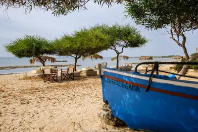 a blue boat sitting on a sandy beach at Thalassines Villas in Ayia Napa