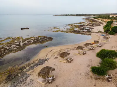 an aerial view of a beach with chairs and umbrellas at Thalassines Villas in Ayia Napa
