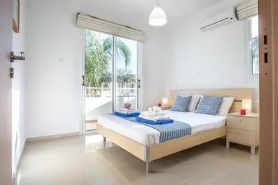 a bedroom with a bed and a large window at Villa Costas in Protaras