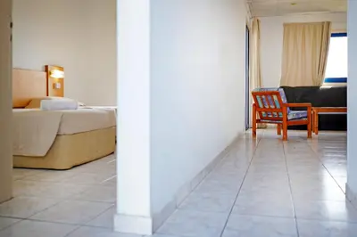 a bedroom with a bed and a chair in a room at Green Bungalows Hotel Apartments in Ayia Napa