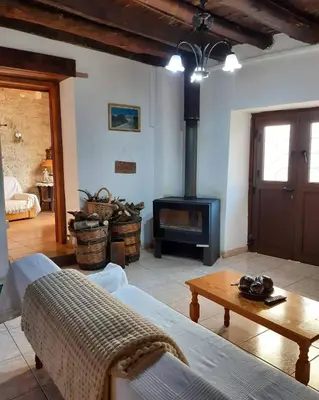 a living room with a fireplace and a couch and a table at John' s House in Omodos in Limassol