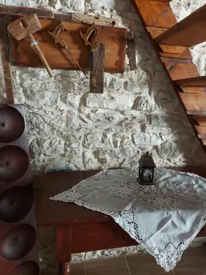 a table in a room with a stone wall at John' s House in Omodos in Limassol