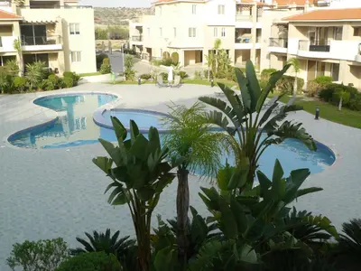an empty swimming pool in front of some buildings at Pyla Gardens E108 in Pyla