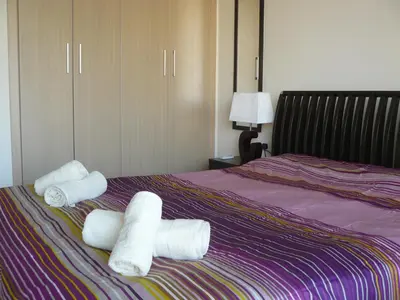 two rolls of towels on top of a bed at Pyla Gardens E108 in Pyla