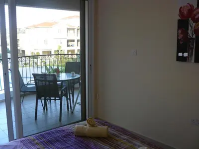 a room with a door leading to a balcony with a table at Pyla Gardens E108 in Pyla