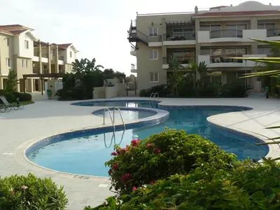 a swimming pool in front of a building at Pyla Gardens E108 in Pyla