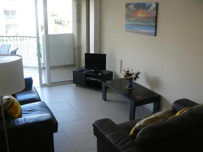 a living room with a couch and a table with a tv at Pyla Gardens E108 in Pyla