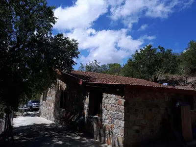a stone building with a tree next to it at Agrompelo House in Agros