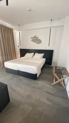 a bedroom with a bed and a chair in it at Abacus Suites in Ayia Napa