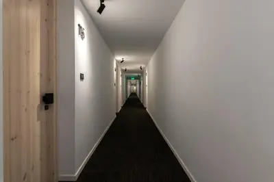a hallway with white walls and a black carpet at Abacus Suites in Ayia Napa