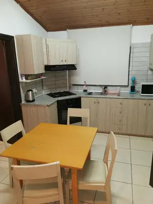 a kitchen with a wooden table and chairs at Strovolos rooms Studios in Nicosia
