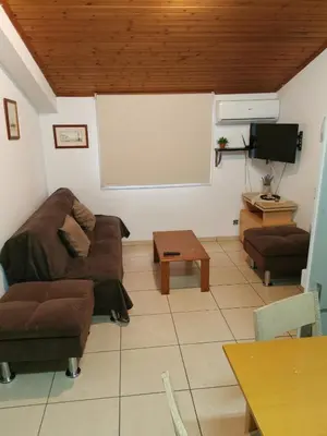 a living room with a couch and a white screen at Strovolos rooms Studios in Nicosia